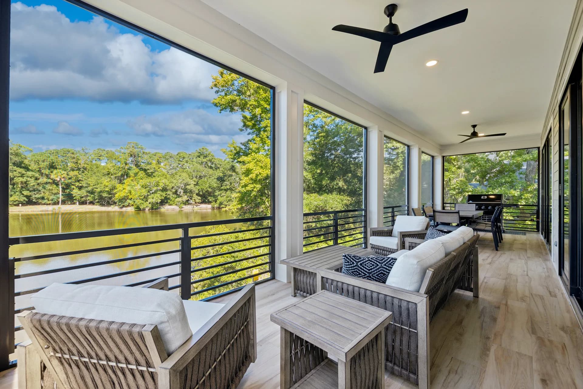 Screened porch seating overlooking water at 16 Indigo Lane
